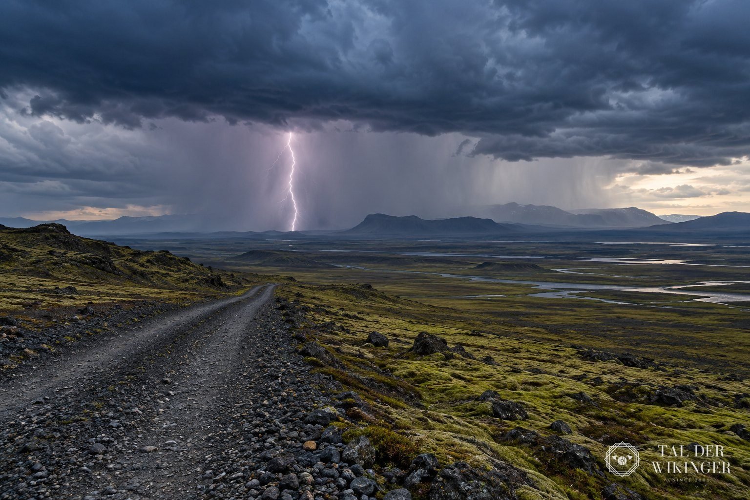 Gewitter mit Blitz über einer weiten isländischen Ebene unter dunklen Wolken